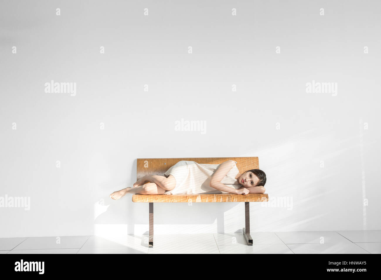 Junge Frau depressiv auf Bank liegend Stockfoto