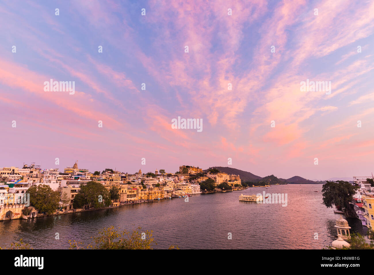 Udaipur Stadtbild mit bunten Himmel bei Sonnenuntergang. Das majestätische Schloss am Lake Pichola, Reiseziel in Rajasthan, Indien Stockfoto