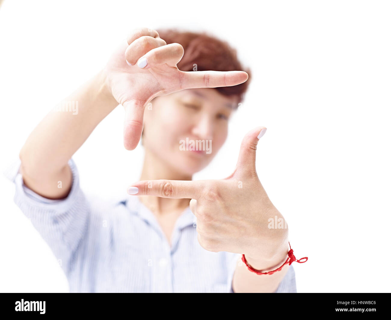 asiatische Frau framing ein Bild mit Händen, isoliert auf weißem Hintergrund. Stockfoto