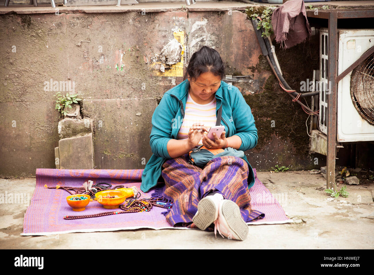 Dharamsala, Indien - 28. September 2014: tibetischer Frau mit einem Smartphone auf dem Straßenmarkt, Dharamsala, Indien. Stockfoto