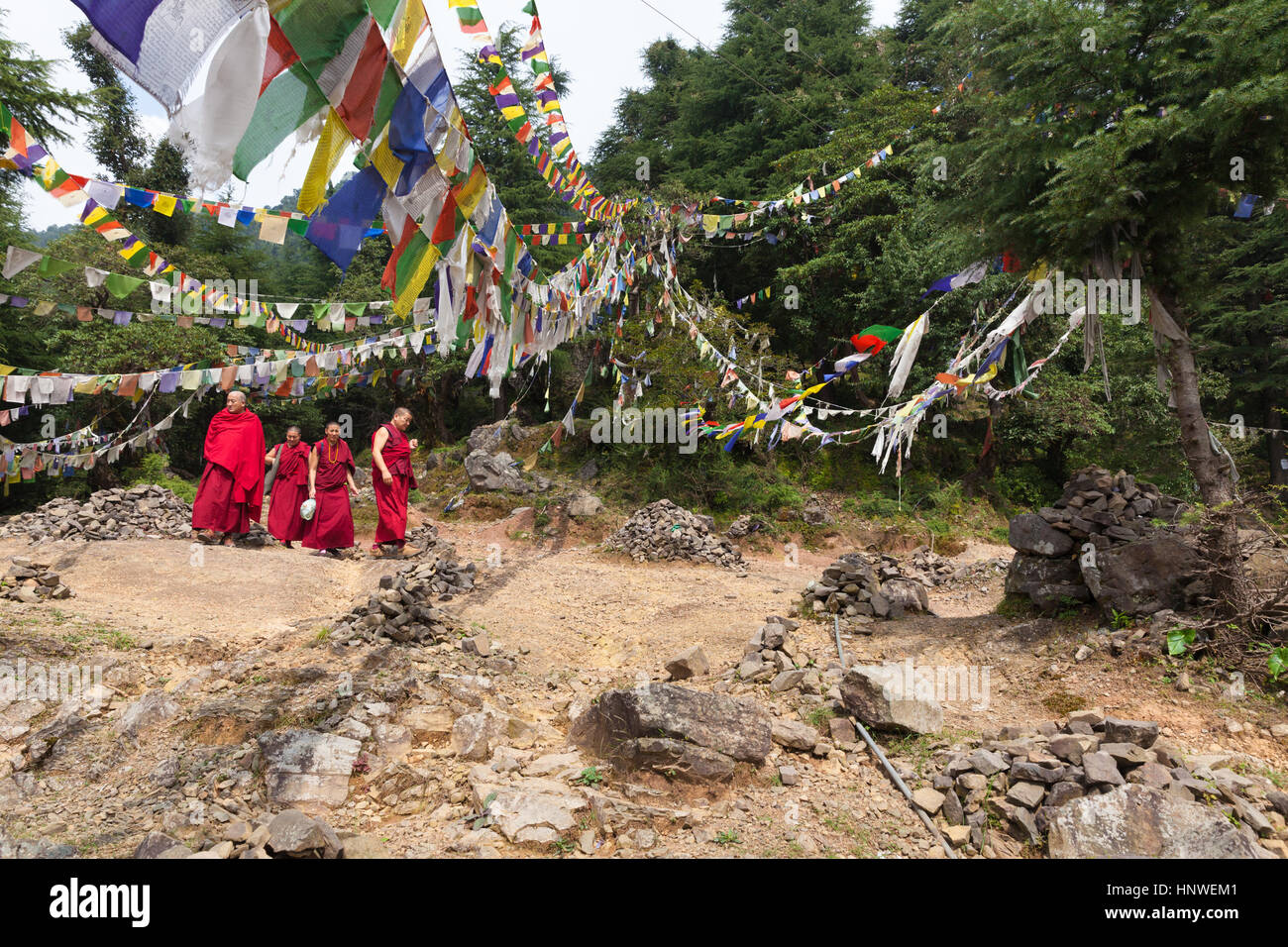 Dharamsala, Indien - 27. September 2014: buddhistische Mönche gehen unter Gebetsfahnen in den Bergen nahe der Stadt McLeod Ganj, Dharamsala, Indien. Stockfoto