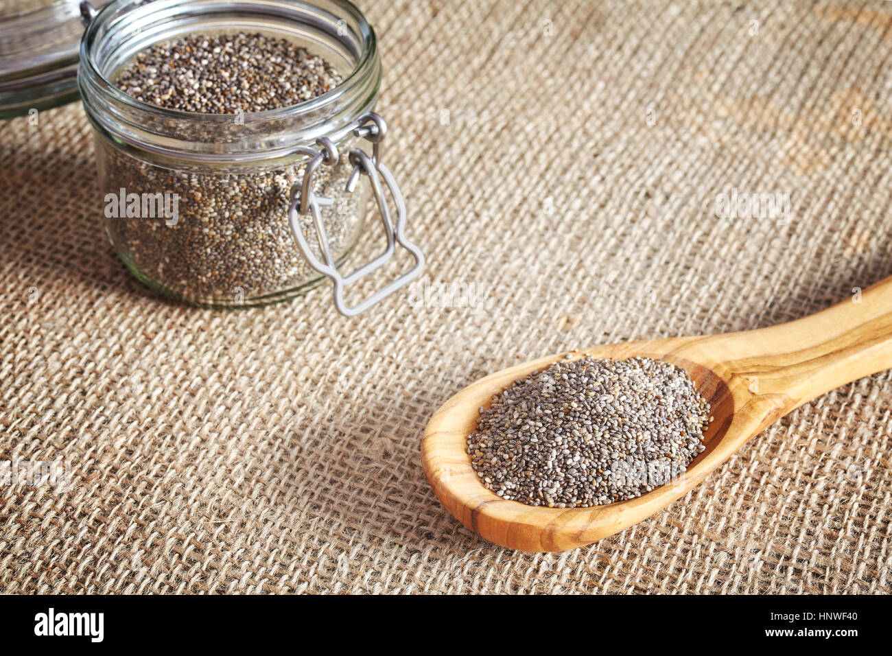 Chia-Samen in einem Holzlöffel und ein Glas, Lebensmittel reich an Omega-3-Fettsäuren. Stockfoto