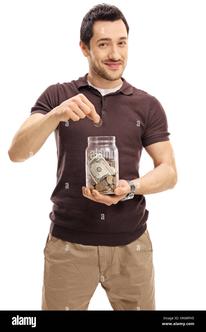 Junger Mann, eine Münze in Glas mit Geld isoliert auf weißem Hintergrund Stockfoto