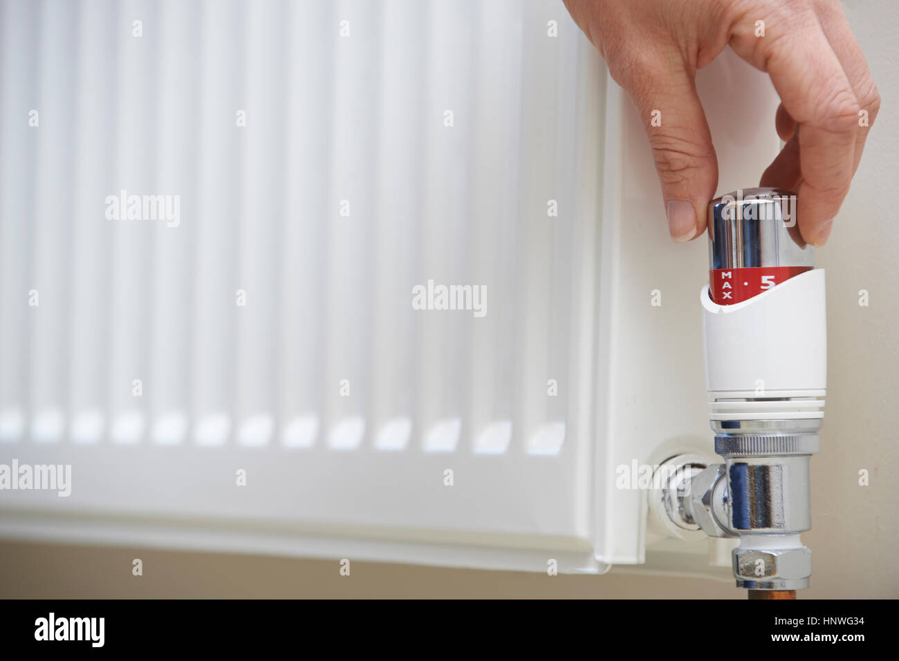 Nahaufnahme von Hand einstellen Heizung Thermostat Stockfoto
