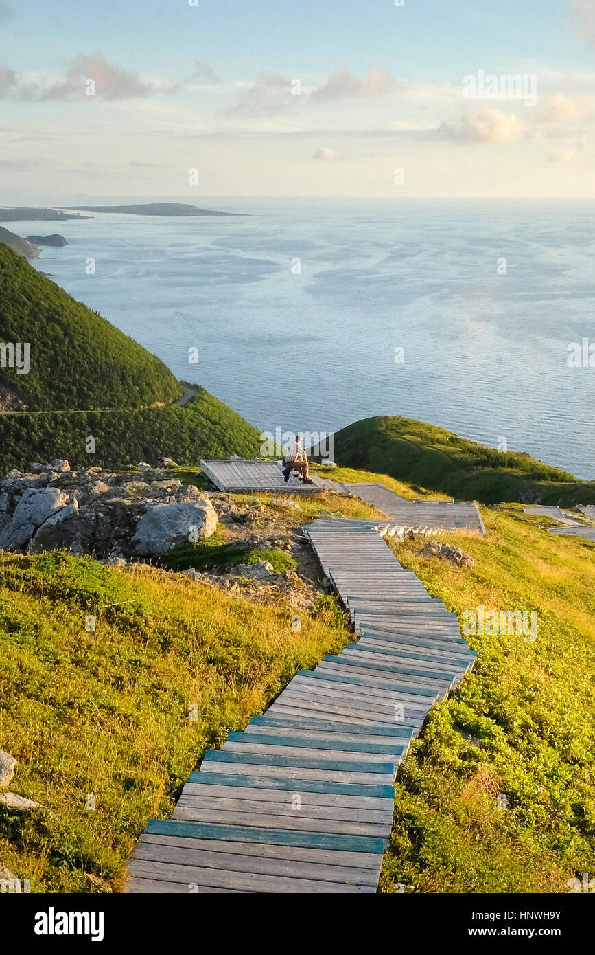 Mann auf Holzstufen auf dem Seeweg, Cape Breton, Nova Scotia, Kanada Stockfoto