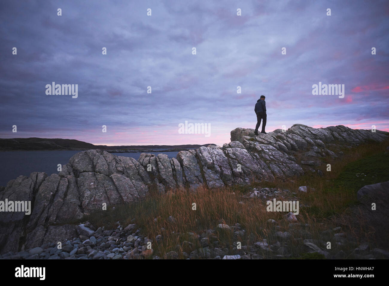 Wanderer, Wandern auf den Felsen in der Abenddämmerung, Fogo Island, Neufundland, Kanada Stockfoto
