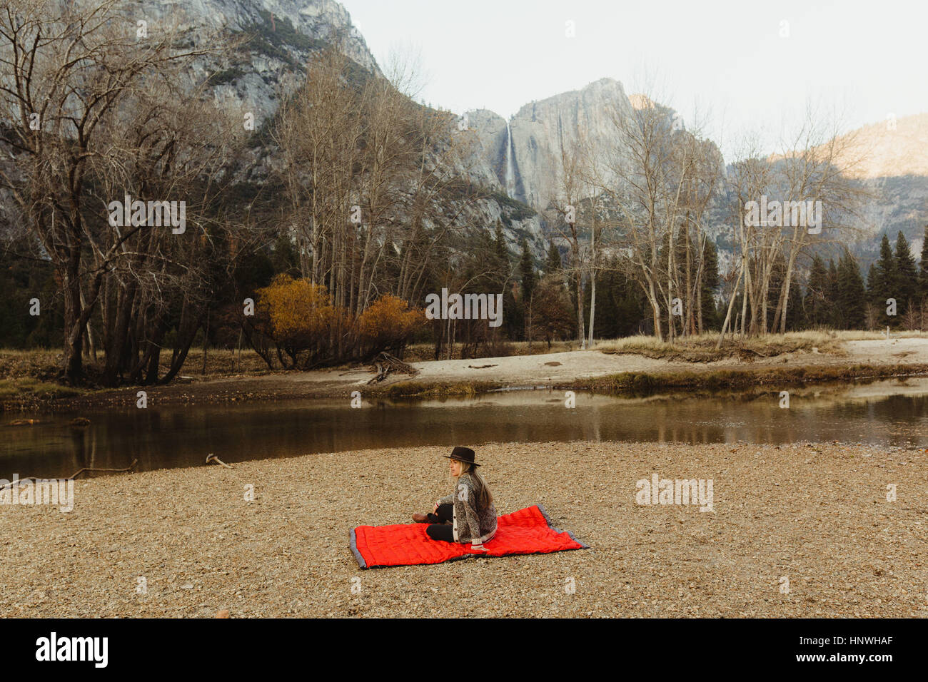 Frau sitzt auf roter Decke mit Blick auf Landschaft, Yosemite-Nationalpark, Kalifornien, USA Stockfoto