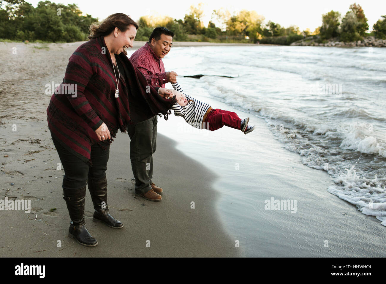 Mutter und Vater auf schwingenden Baby Beachboy, Toronto, Ontario, Kanada Stockfoto