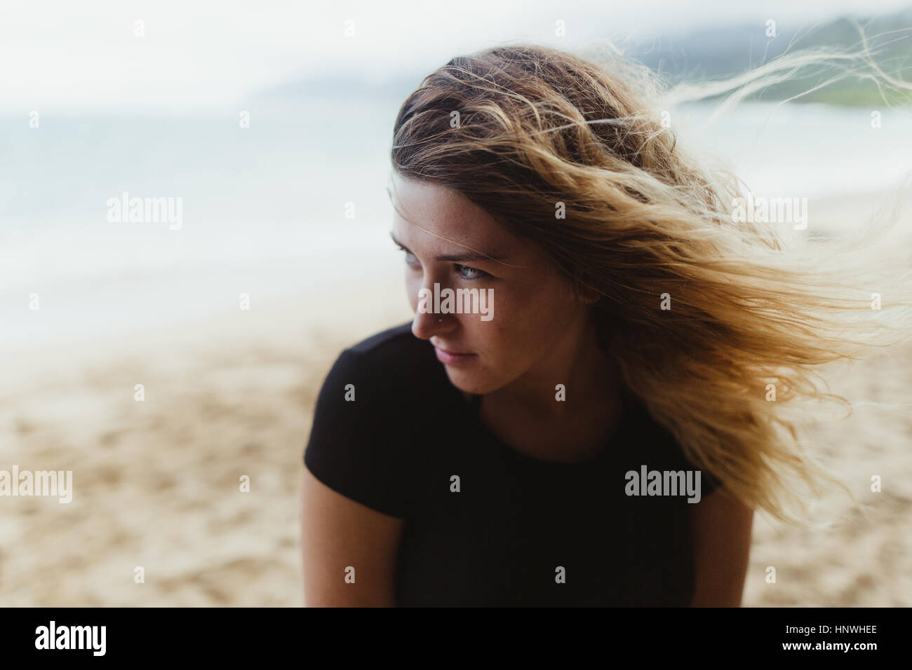 Porträt der Frau am Strand wegsehen, Oahu, Hawaii, USA Stockfoto