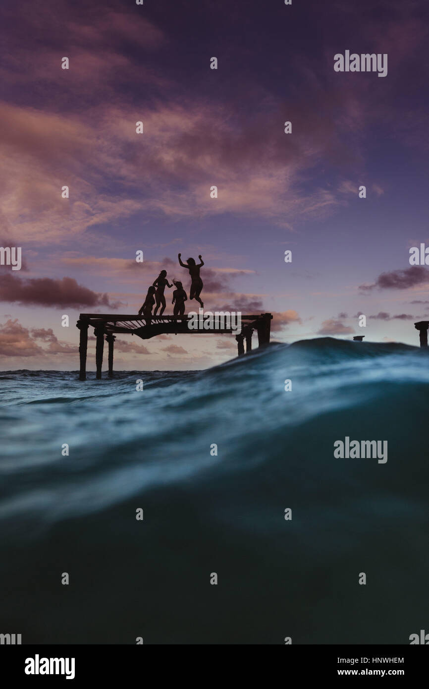 Silhouette der Freunde hüpfen auf dem Trampolin im Meer, Oahu, Hawaii, USA Stockfoto
