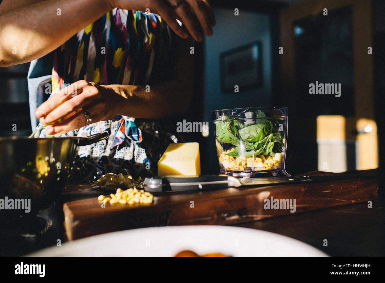 Frau, die Zubereitung von Pasta mit Basilikum, Pinienkernen Stockfoto