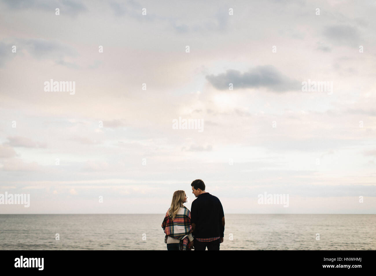 Junges Paar im Freien, Rückansicht am Meer, Stockfoto