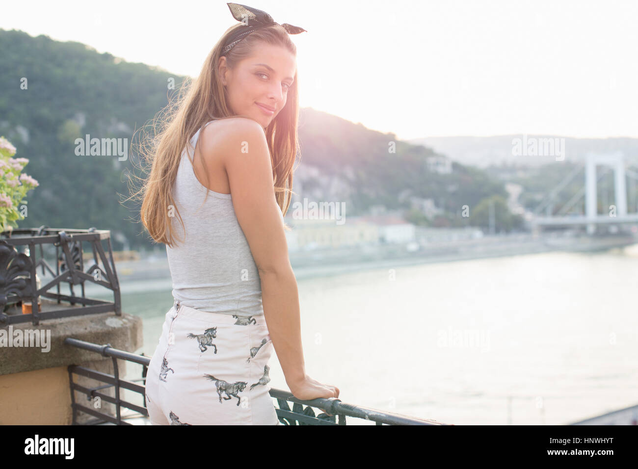 Porträt der jungen Frau, die im Rückblick auf Dach-Terrasse am Wasser, Budapest, Ungarn Stockfoto