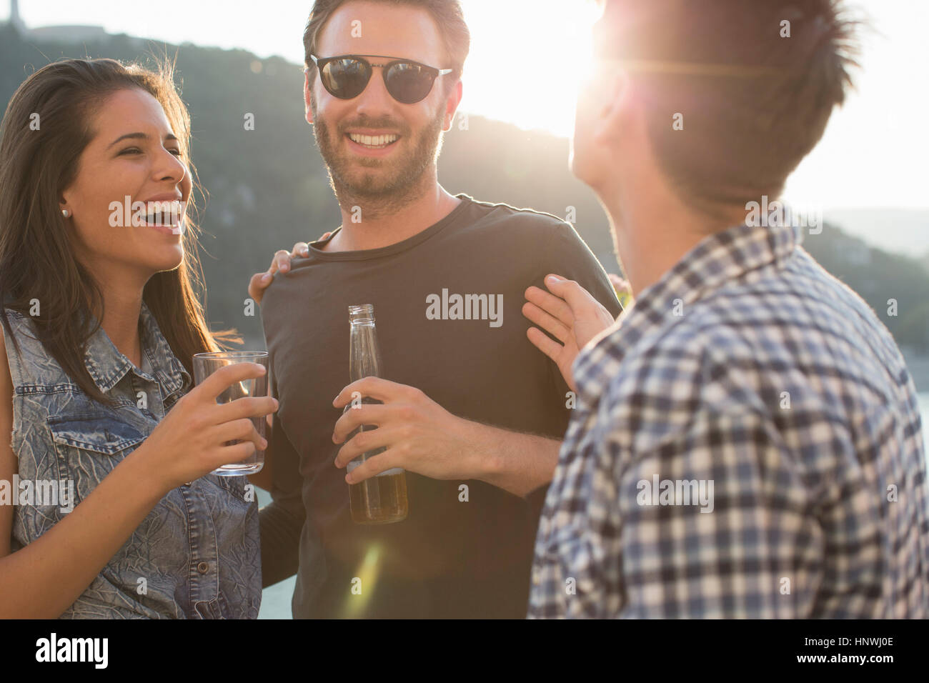 Drei Erwachsene Freunde lachen und feiern auf Dachterrasse Stockfoto