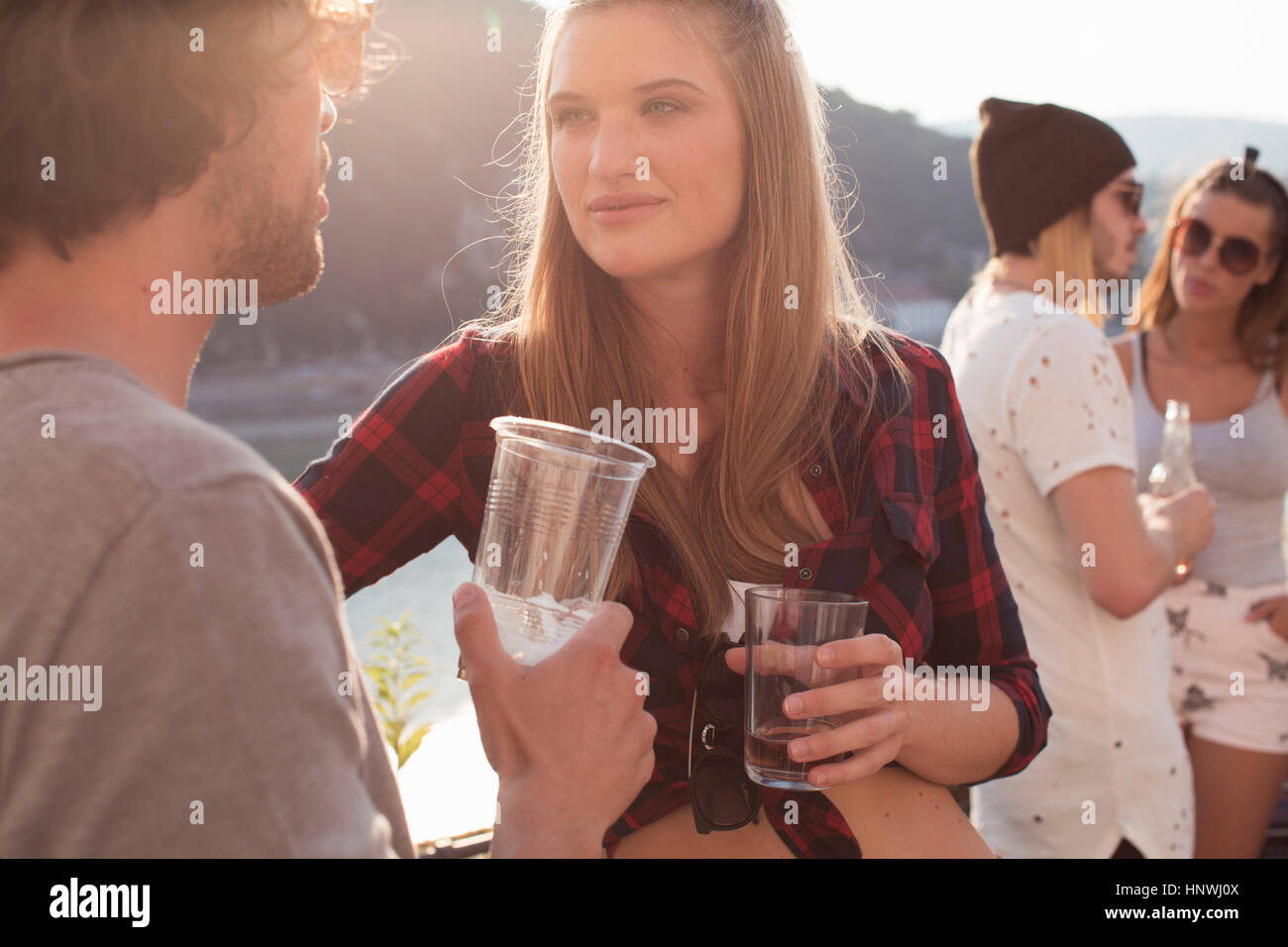 Paare im Chat auf Dach Terrasse Party, Budapest, Ungarn Stockfoto