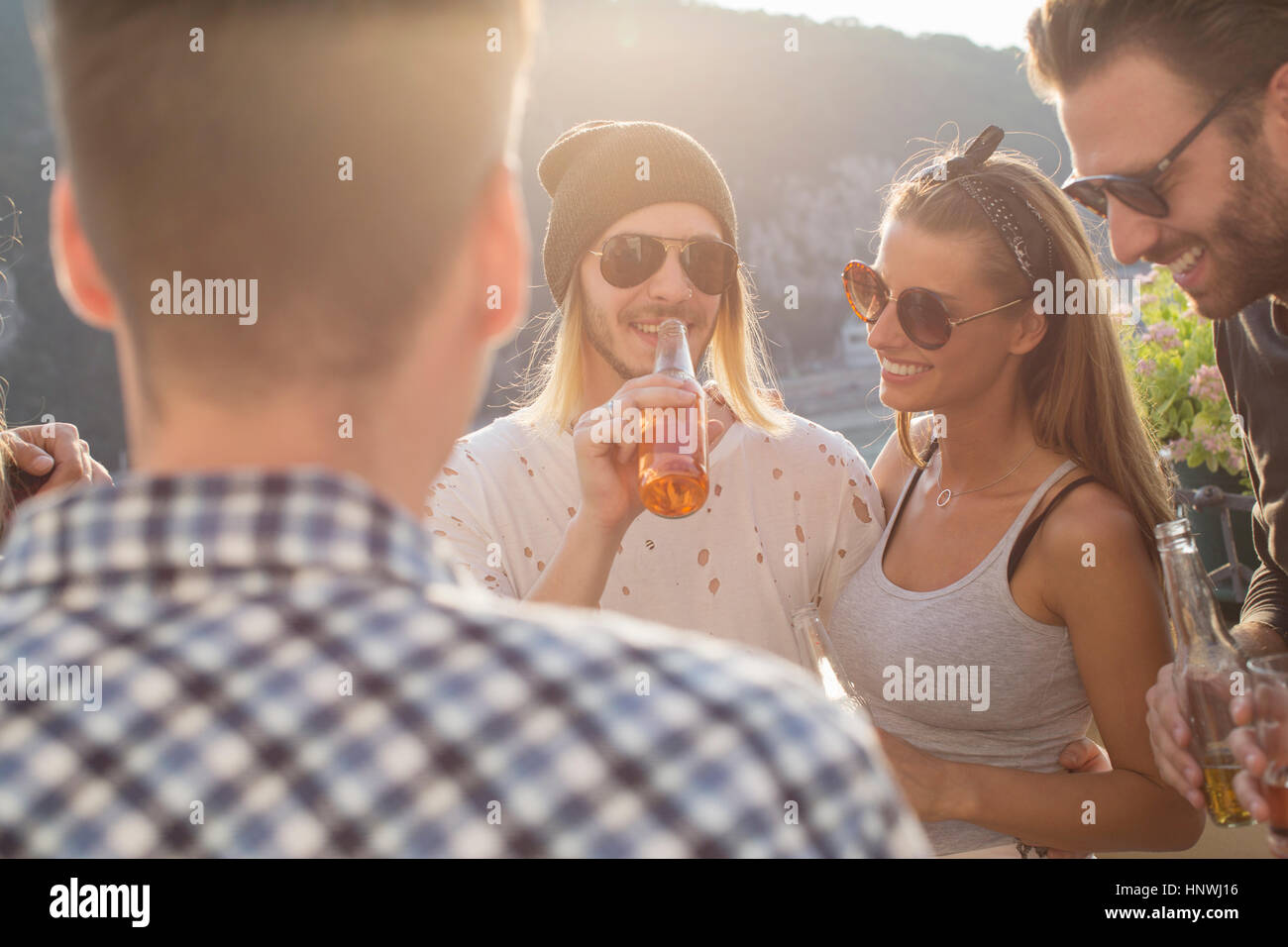 Erwachsene Freunde feiern mit Flaschenbier auf Dachterrasse Stockfoto