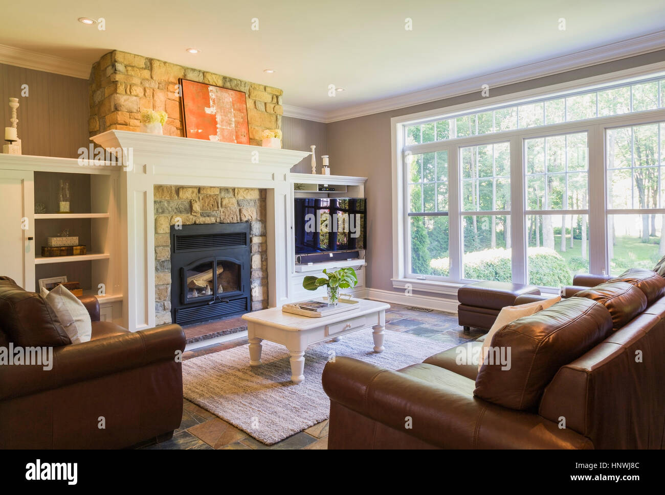 Braune Ledercouch, sitzen, liegen und Kamin aus Naturstein im Wohnzimmer in  einem Cottage-Stil nach Hause, Quebec, Kanada Stockfotografie - Alamy