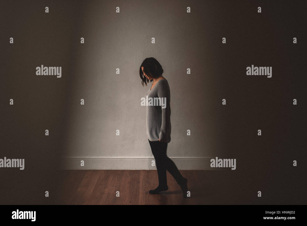 Frau vor grauen Wand Tempo Stockfoto