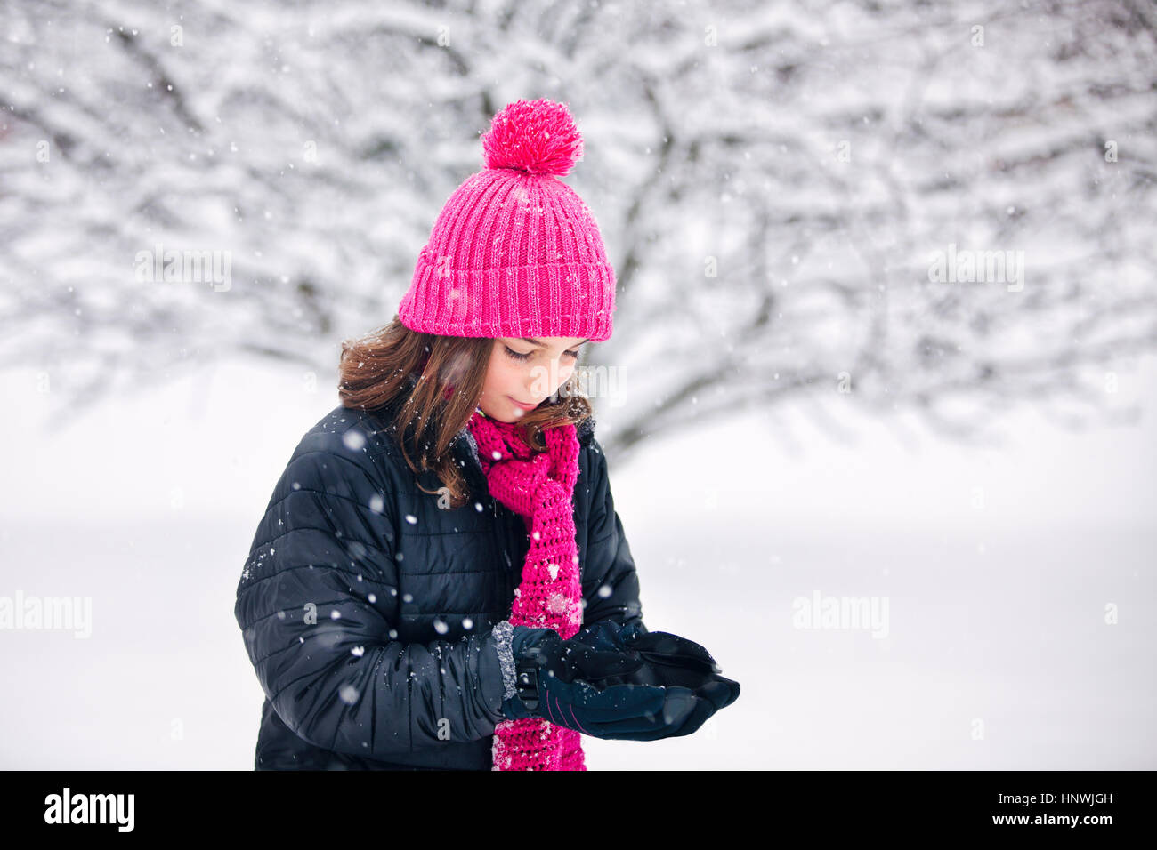 Mädchen Schröpfen Hände fangen fallenden Schnee Stockfoto