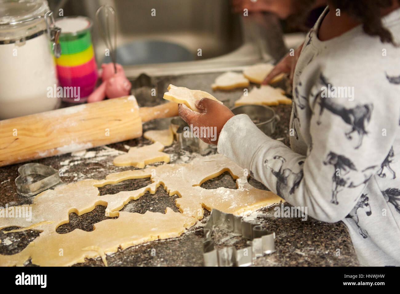 Mädchen schneiden Cookie-Teig mit Ausstechformen Stockfoto