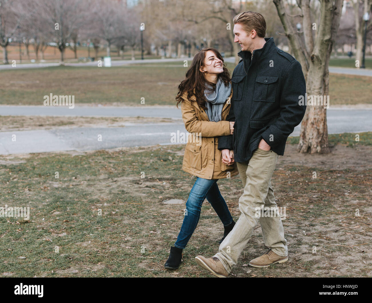 Junges Paar zu Fuß durch den Park, arm in Arm, Lächeln Stockfoto
