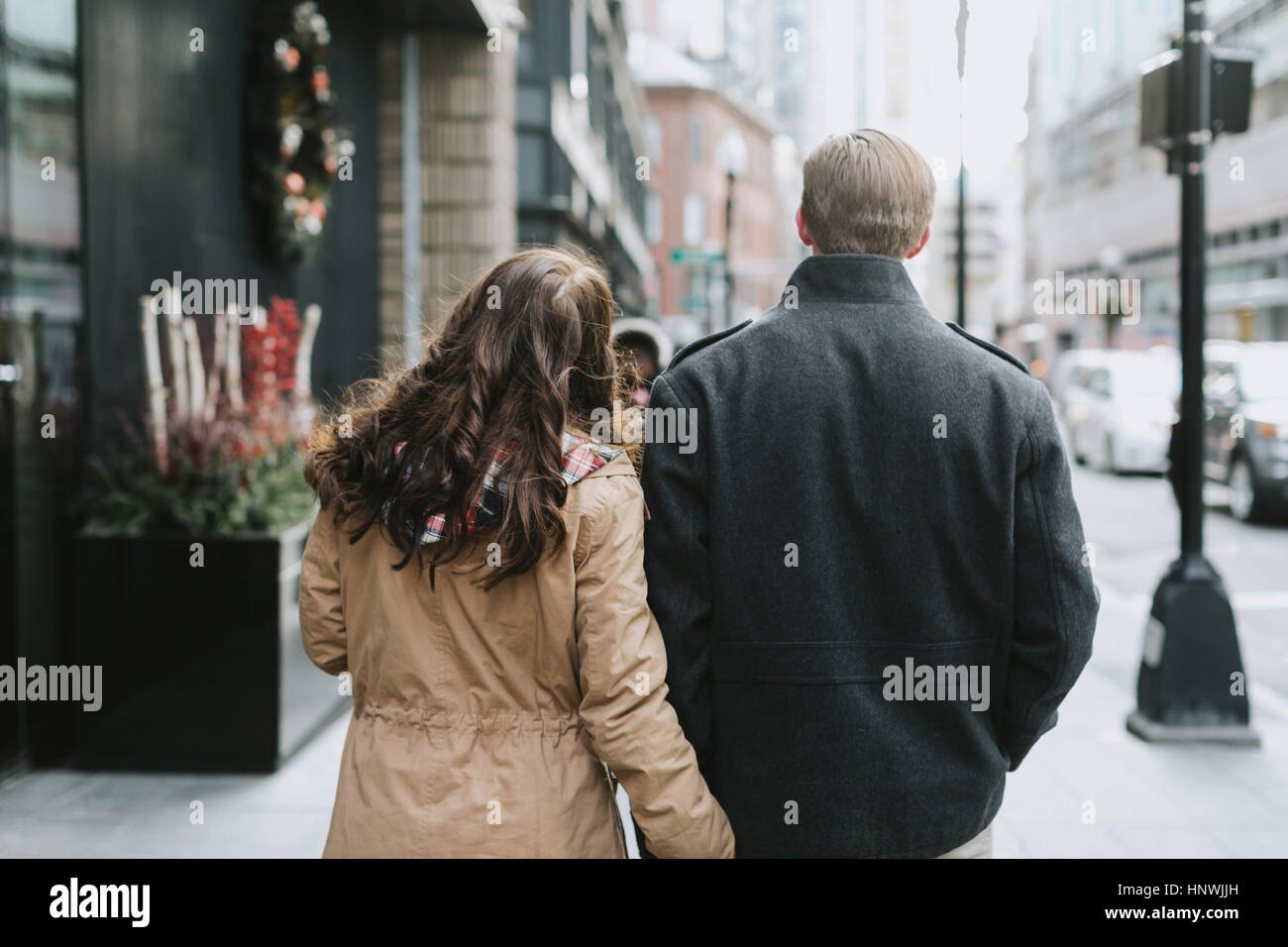 Junges Paar zu Fuß entlang der Straße, Rückansicht Stockfoto
