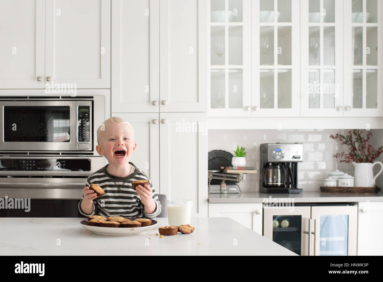 Kleiner Junge in Küche, Kuchen, lächelnd gebacken frisch halten Stockfoto