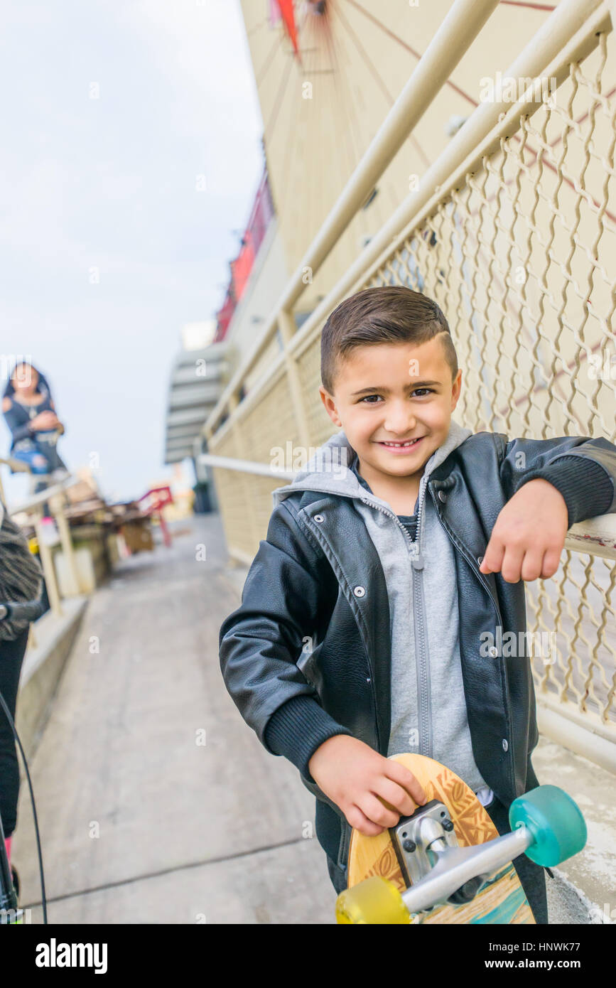 Porträt von süsser Boy mit Skateboards urban Reling gelehnt Stockfoto