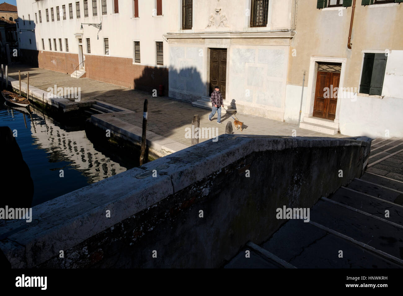 Der Mensch seinen Hund an einem Kanal entlang. Venedig, Italien Stockfoto