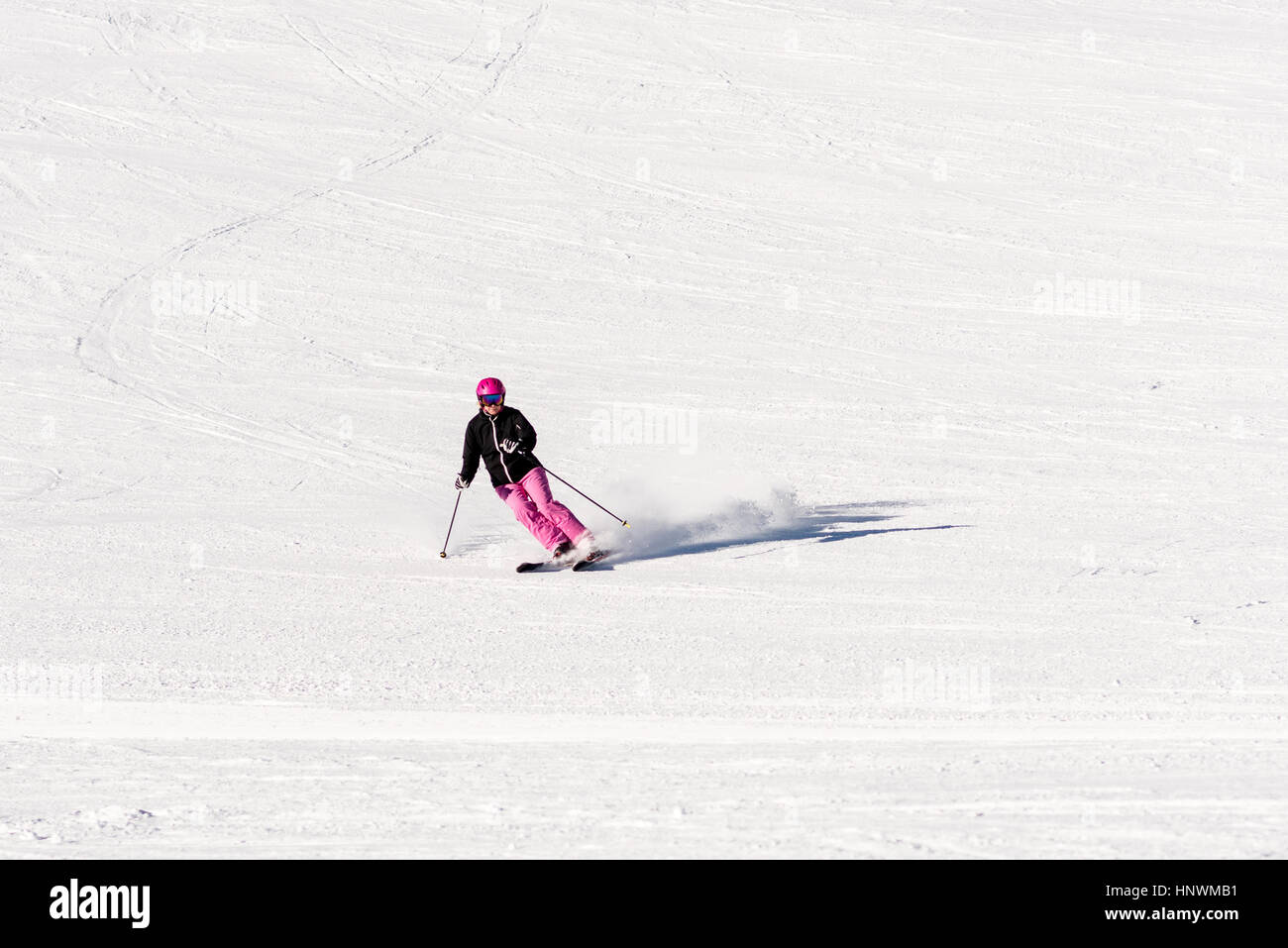 Skifahrerin auf leere Skipiste Stockfoto