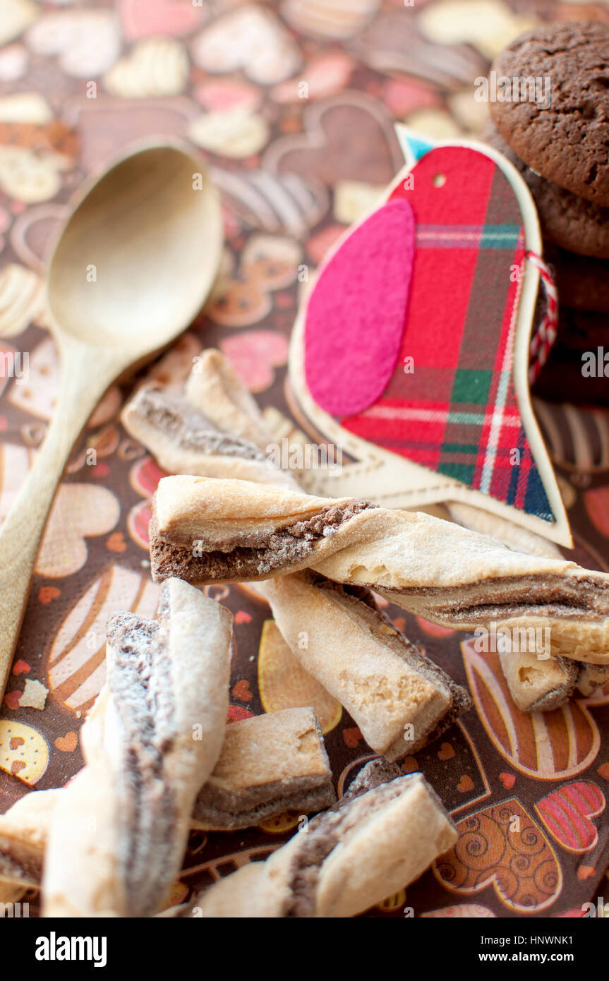 Roter Spielzeug Vogel und Cookies auf dunklen Serviette mit Bild des Heartsclose auf. Selektiven Fokus. Stockfoto