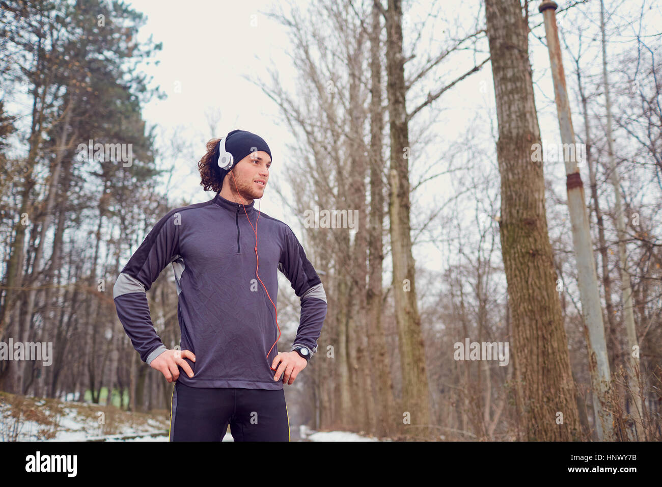 Sport-Guy in Kopfhörer und Hut im park Stockfoto