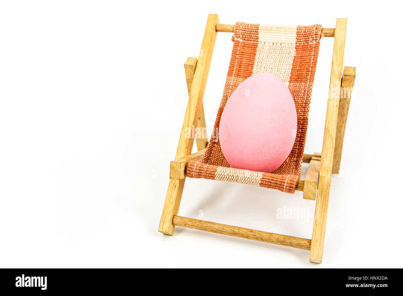 Rosa Ei am Strand Stuhl abstrakten Hintergrund für den Sommer, Ostern Urlaub Konzept. Stockfoto