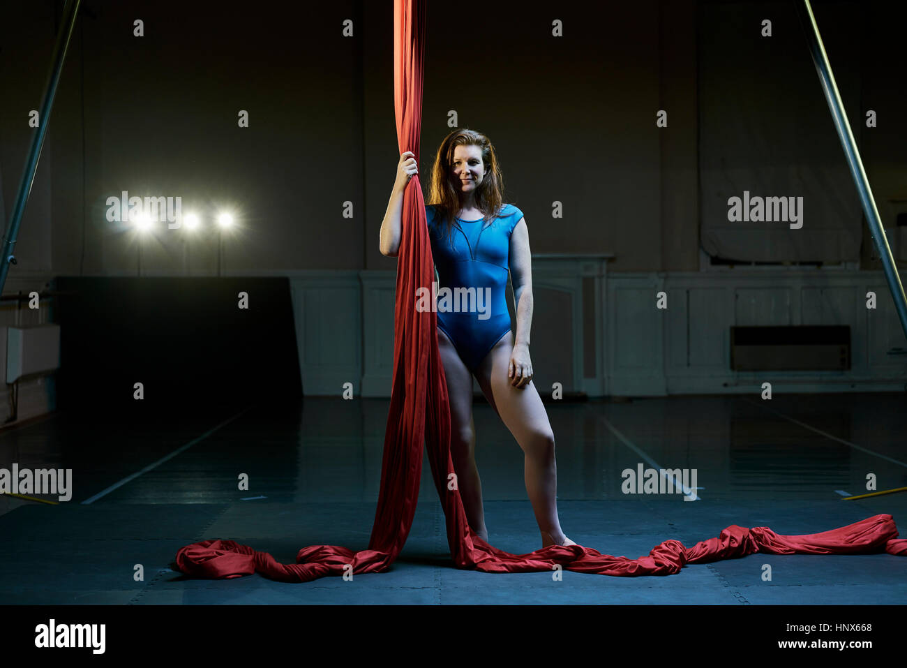 Porträt der jungen weiblichen Antenne Acrobat halten rote Seide Seil Stockfoto