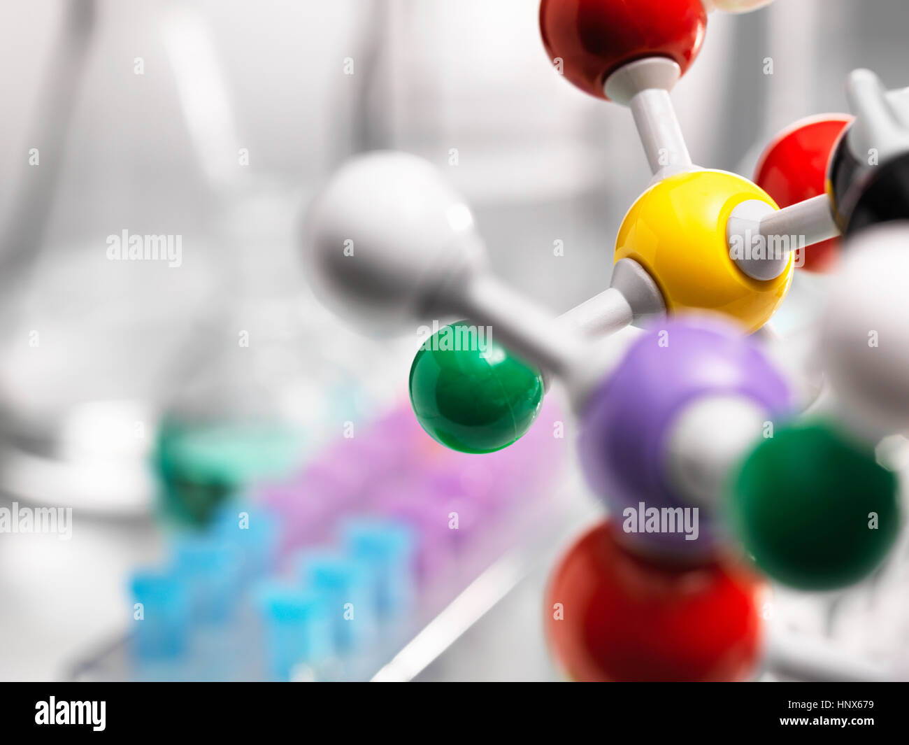 Ein molekulares Modell einer chemischen Formel mit Laborgeräten im Hintergrund Stockfoto