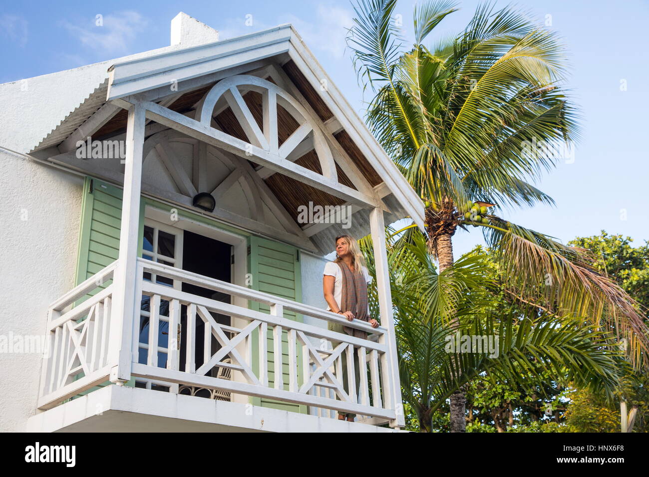 Reife Frau steht auf Balkon des Hauses, Roches Noire, Mauritius Stockfoto
