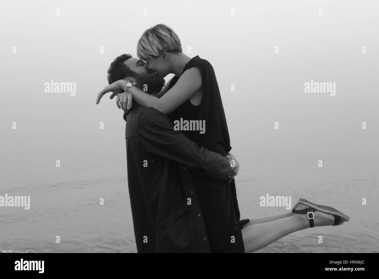 Junges Paar am Strand, umarmen und küssen Stockfoto