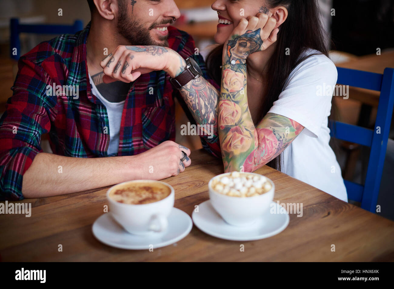Paar im Café lächelnd von Angesicht zu Angesicht Stockfoto