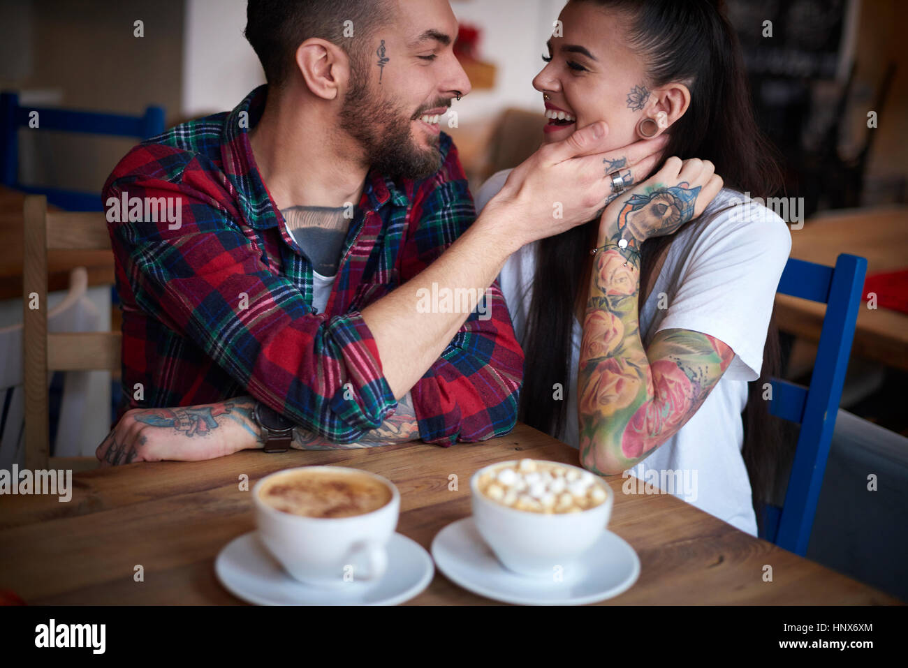 Paar im Café lächelnd von Angesicht zu Angesicht Stockfoto