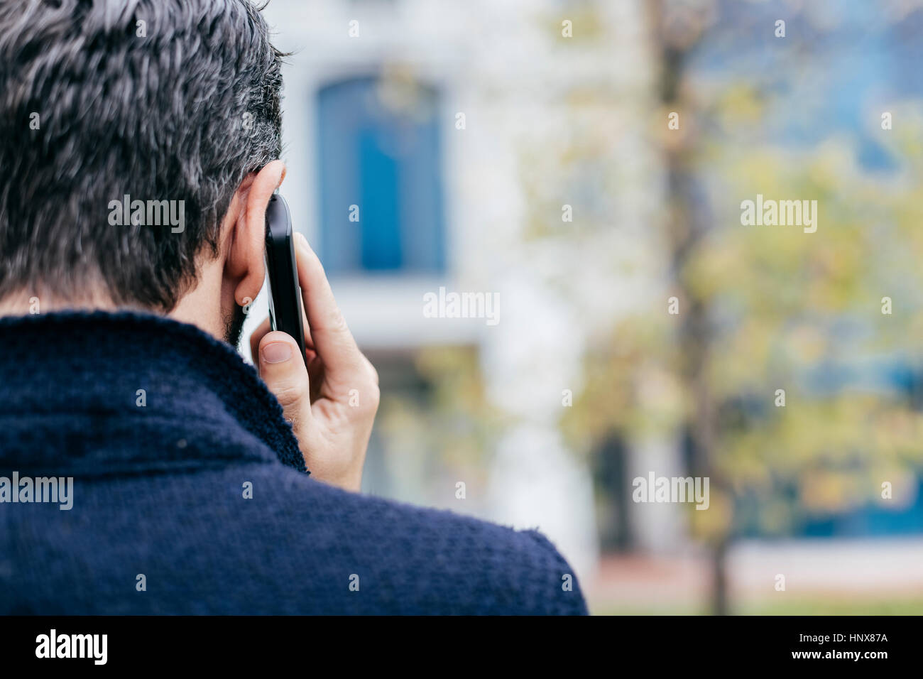 Rückansicht des Mannes mit Mobiltelefon Stockfoto