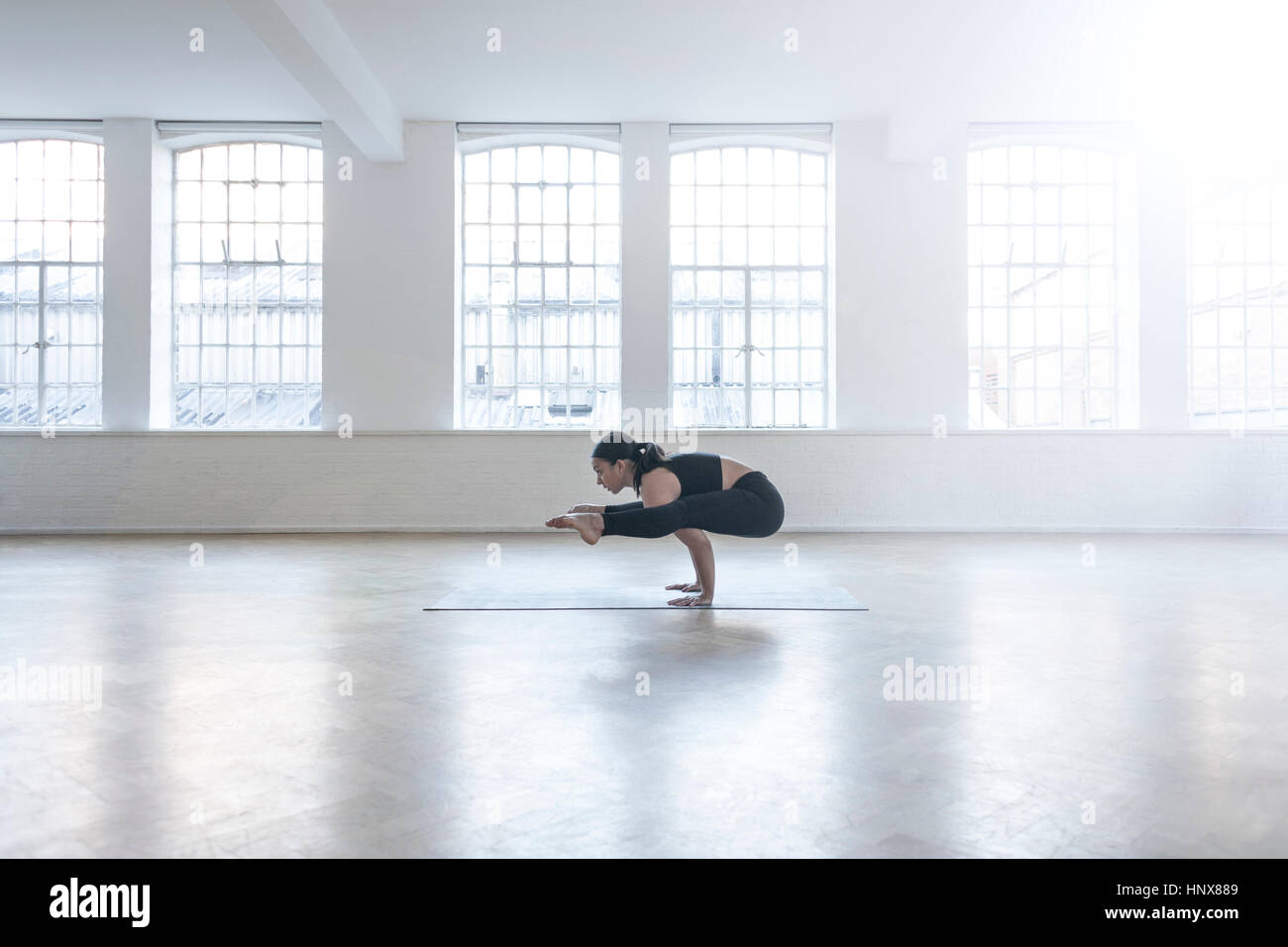 Frau im Tanzstudio in Yogaposition Stockfoto