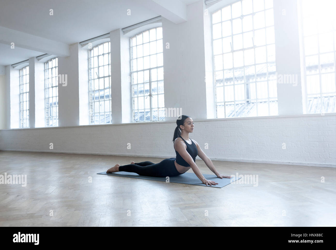 Frau im Tanzstudio in Yogaposition Stockfoto
