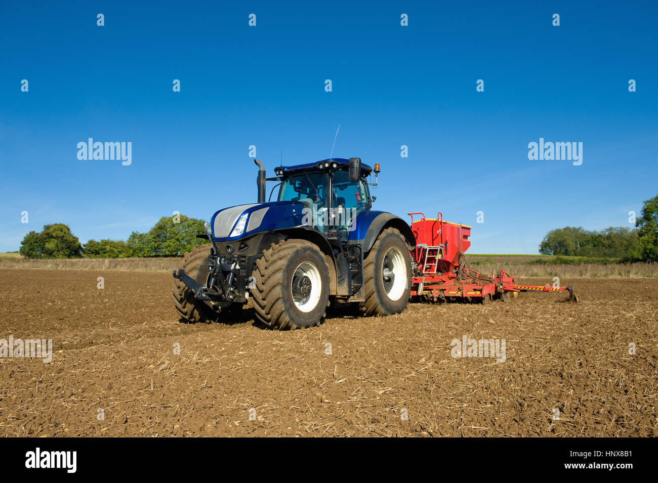 Farmer Traktor mit Sämaschine im Acker zu fahren, im Frühjahr Stockfoto