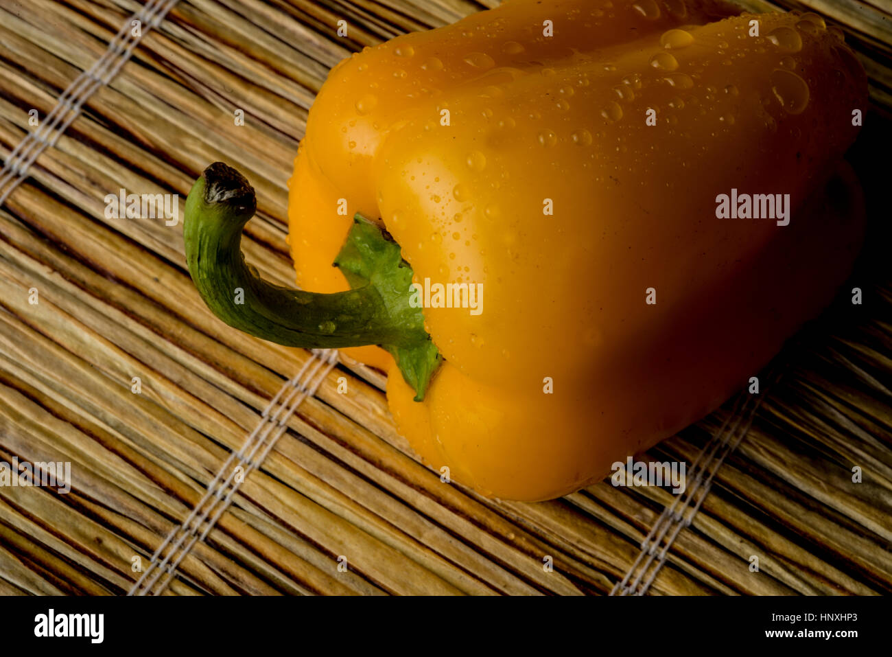 gelbe Paprika auf eine Strohmatte Stockfoto