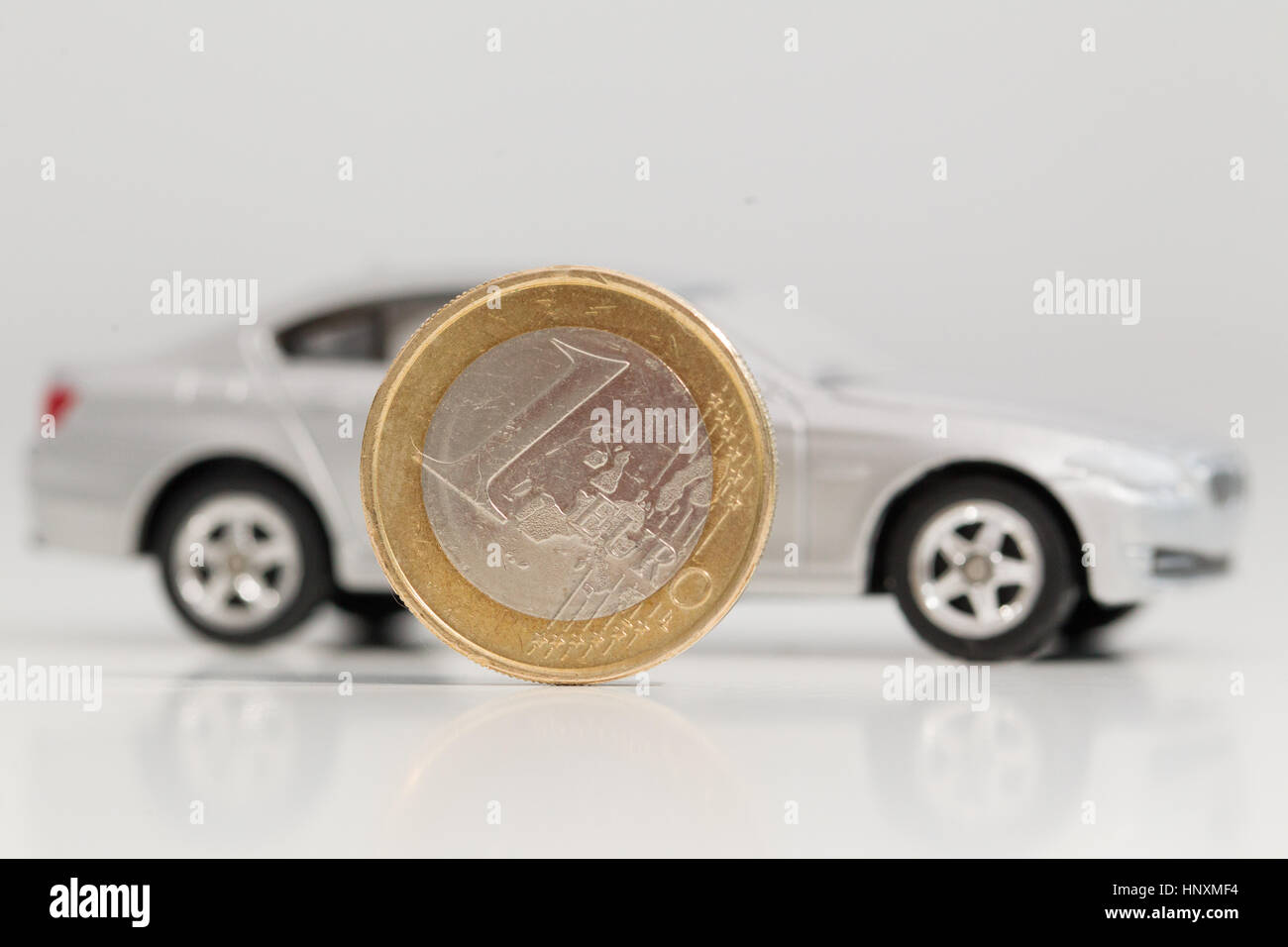 Ein Modellauto wird mit Euro-Währung-Einheiten gesehen. Stockfoto