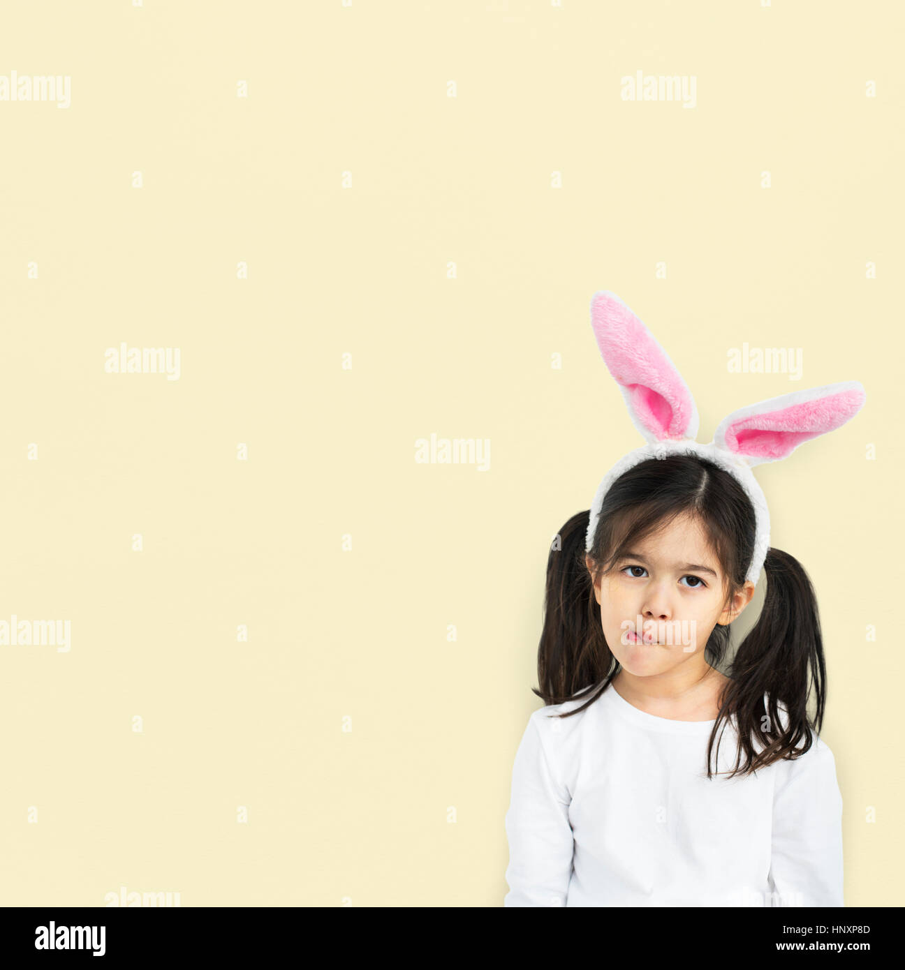 Kleines Mädchen mit Hase Ohren neugierig Studio Stockfoto