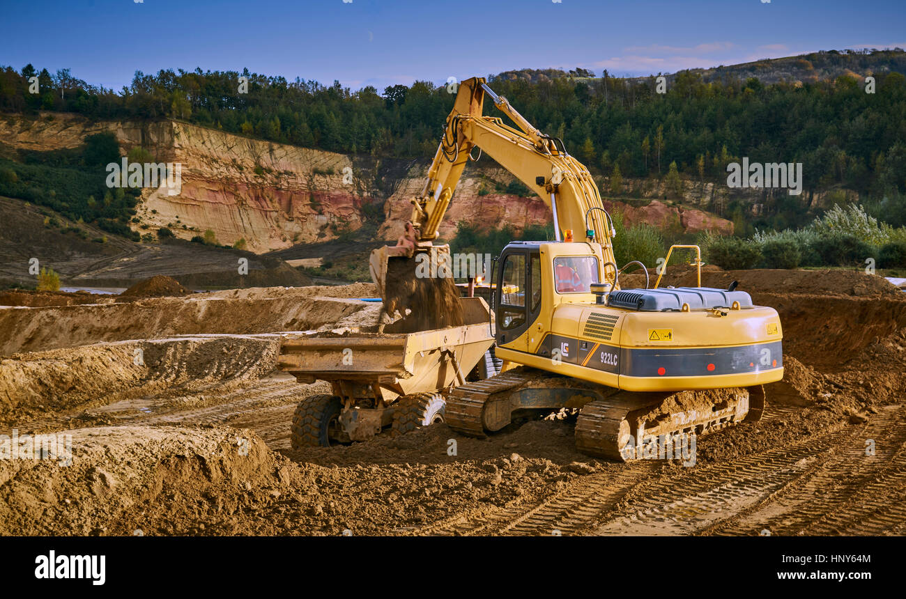 Gewinnung von Sand mit einem Bagger und Kipper in einem Steinbruch Stockfoto