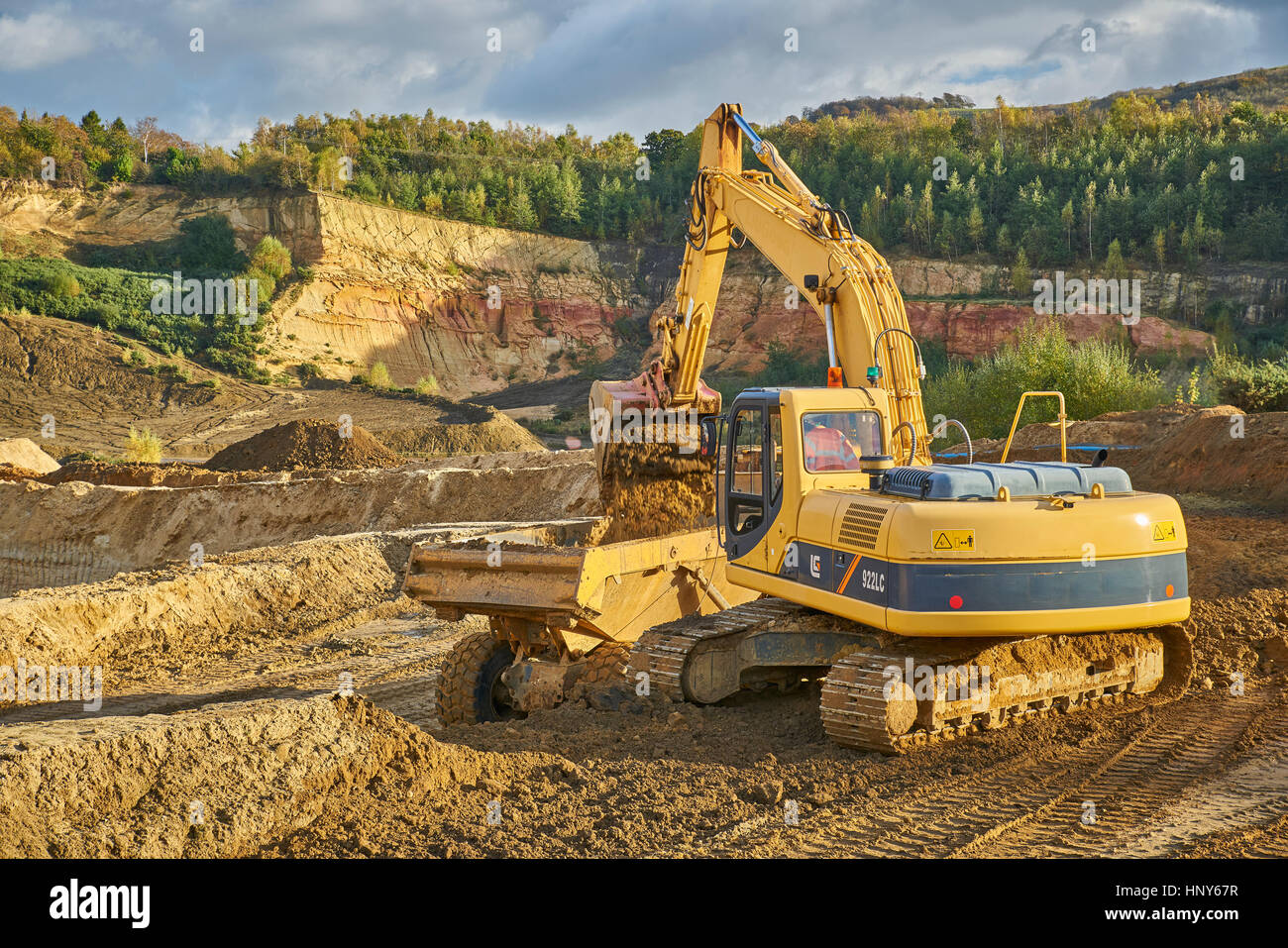 Gewinnung von Sand mit einem Bagger und Kipper in einem Steinbruch Stockfoto