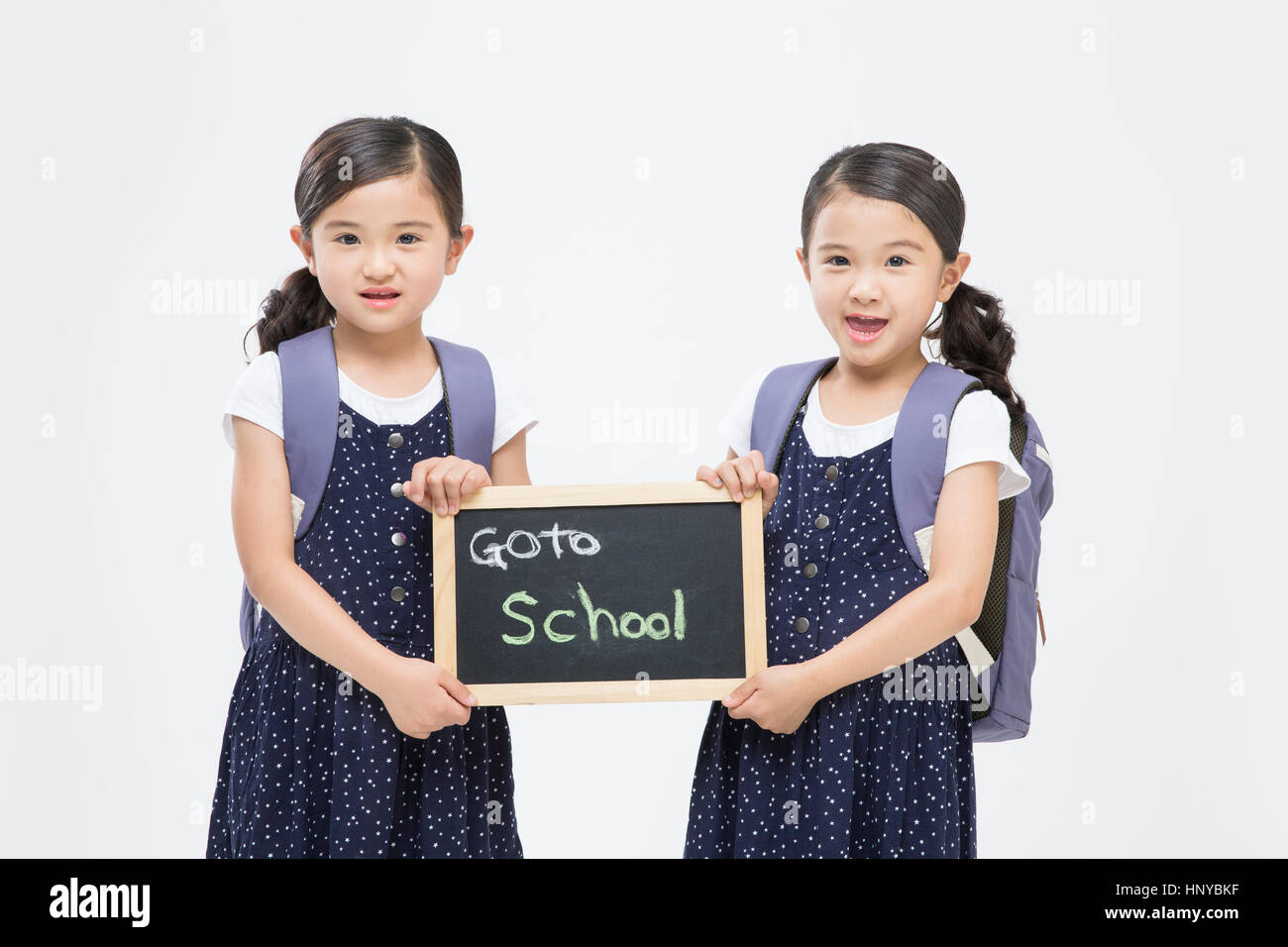 Lächelnde Zwillingsmädchen, die Schule zu gehen Stockfoto