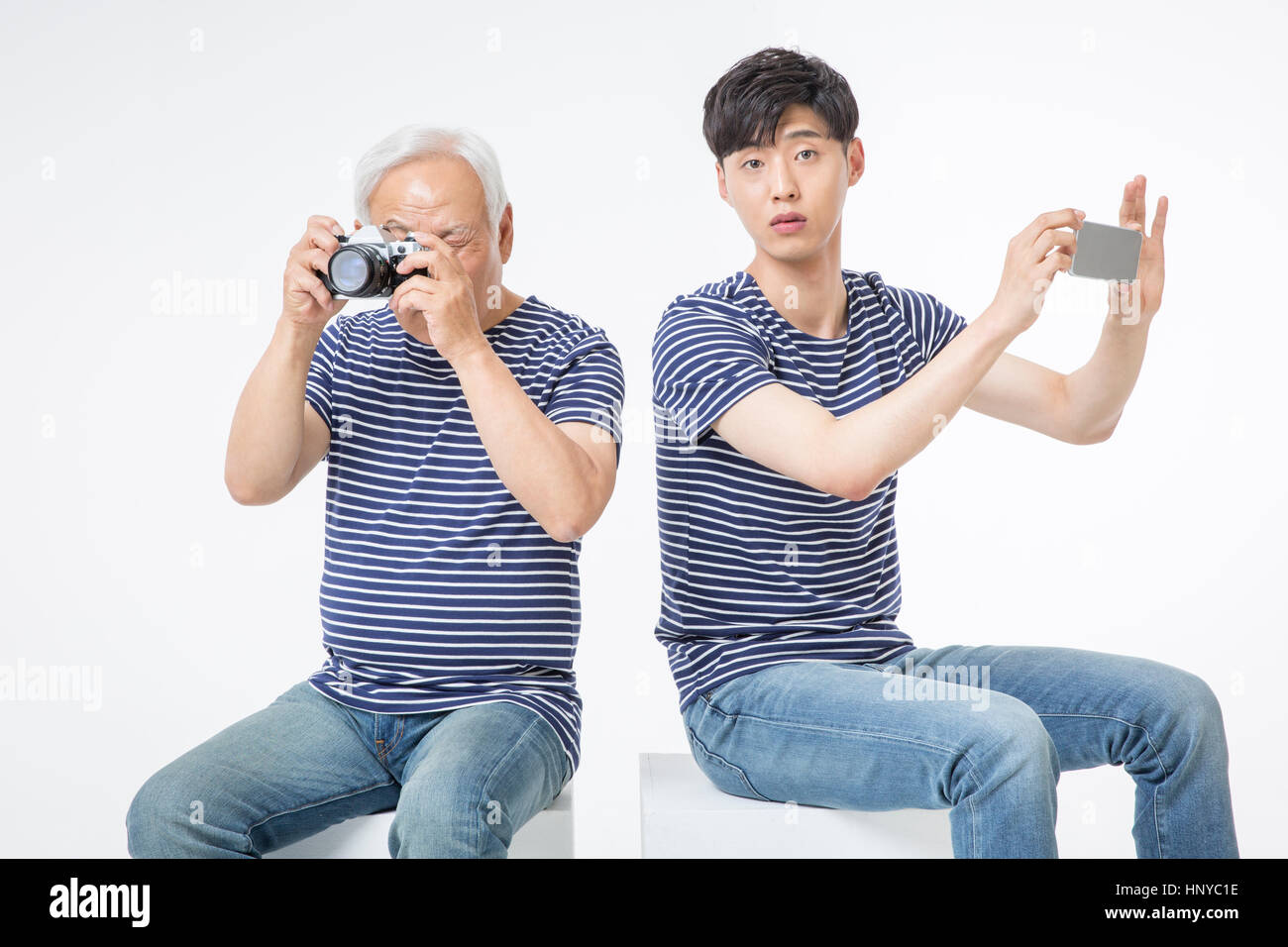 Ältere Mann mit Kamera und junger Mann mit smartphone Stockfoto